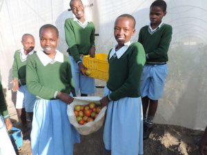 Photo: Kitechild: School children at the Fiwagoh home, showing the harvest from our greenhouse project, that works to fund their education.